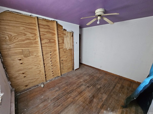 unfurnished bedroom featuring baseboards, hardwood / wood-style flooring, and ceiling fan