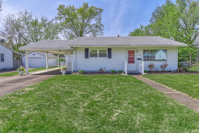 ranch-style house with a shingled roof, a front lawn, an outdoor structure, and concrete driveway
