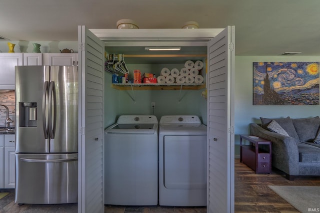 clothes washing area with wood finished floors, visible vents, washer and dryer, and laundry area
