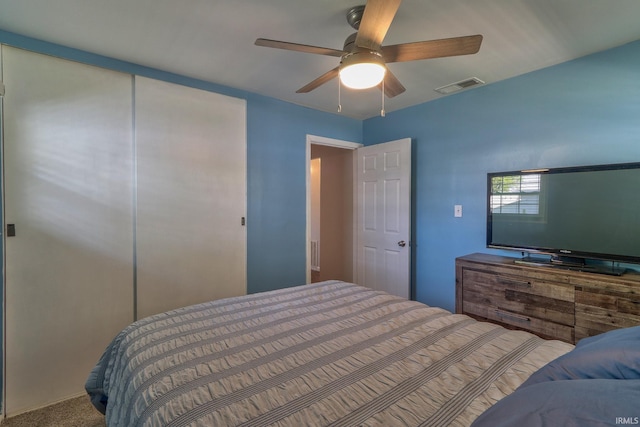 carpeted bedroom featuring a ceiling fan, visible vents, and a closet