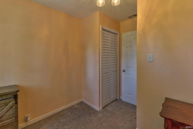 interior space featuring a closet, visible vents, carpet flooring, and baseboards
