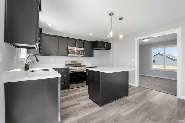 1010 Bryce Cir, Ligonier, IN 46797 - kitchen featuring a sink, pendant lighting, stainless steel appliances, light wood-style flooring, and dark cabinets
