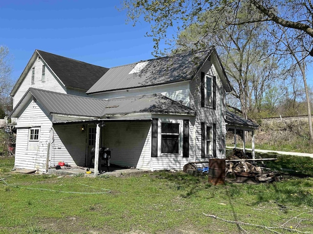 exterior space with a lawn, a patio, and metal roof
