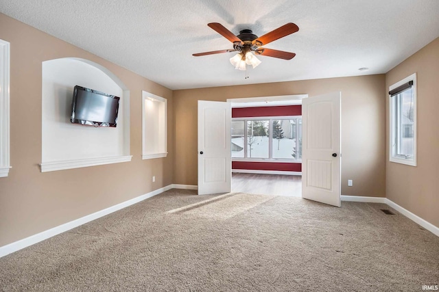 3018 Caradoza Cv, Fort Wayne, IN 46825 - carpeted empty room featuring baseboards, ceiling fan, a textured ceiling, and visible vents