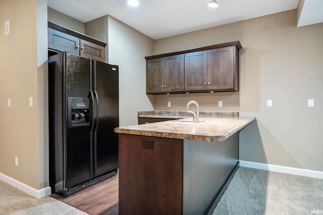 3018 Caradoza Cv, Fort Wayne, IN 46825 - kitchen with black fridge with ice dispenser, a peninsula, dark brown cabinetry, baseboards, and light countertops
