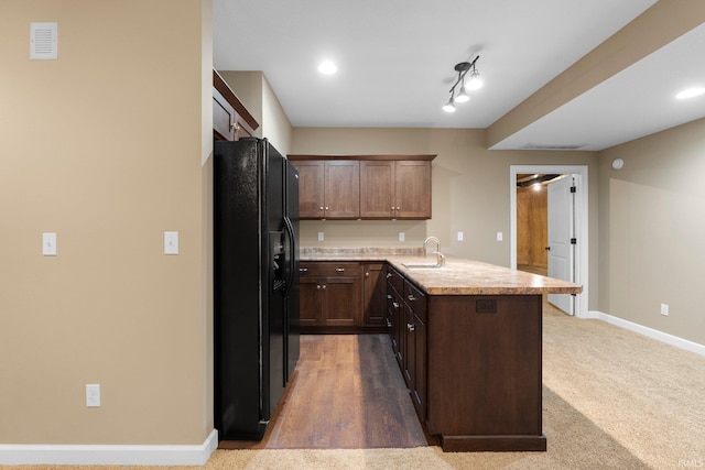 3018 Caradoza Cv, Fort Wayne, IN 46825 - kitchen featuring black fridge with ice dispenser, visible vents, a peninsula, baseboards, and a sink