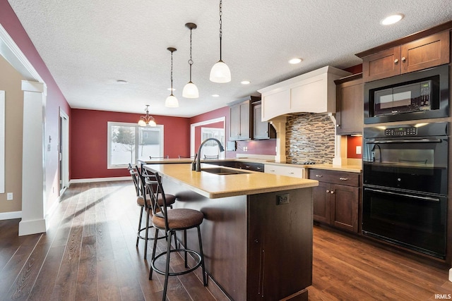 3018 Caradoza Cv, Fort Wayne, IN 46825 - kitchen featuring dark wood-type flooring, light countertops, tasteful backsplash, a sink, and black appliances