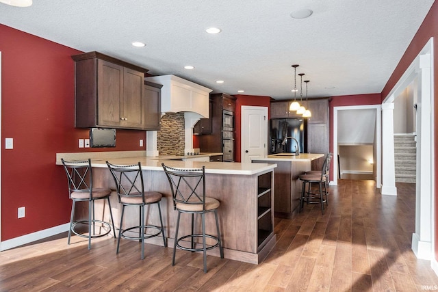 3018 Caradoza Cv, Fort Wayne, IN 46825 - kitchen with dark wood-style flooring, light countertops, baseboards, a peninsula, and black refrigerator with ice dispenser