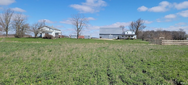view of yard with fence and a rural view