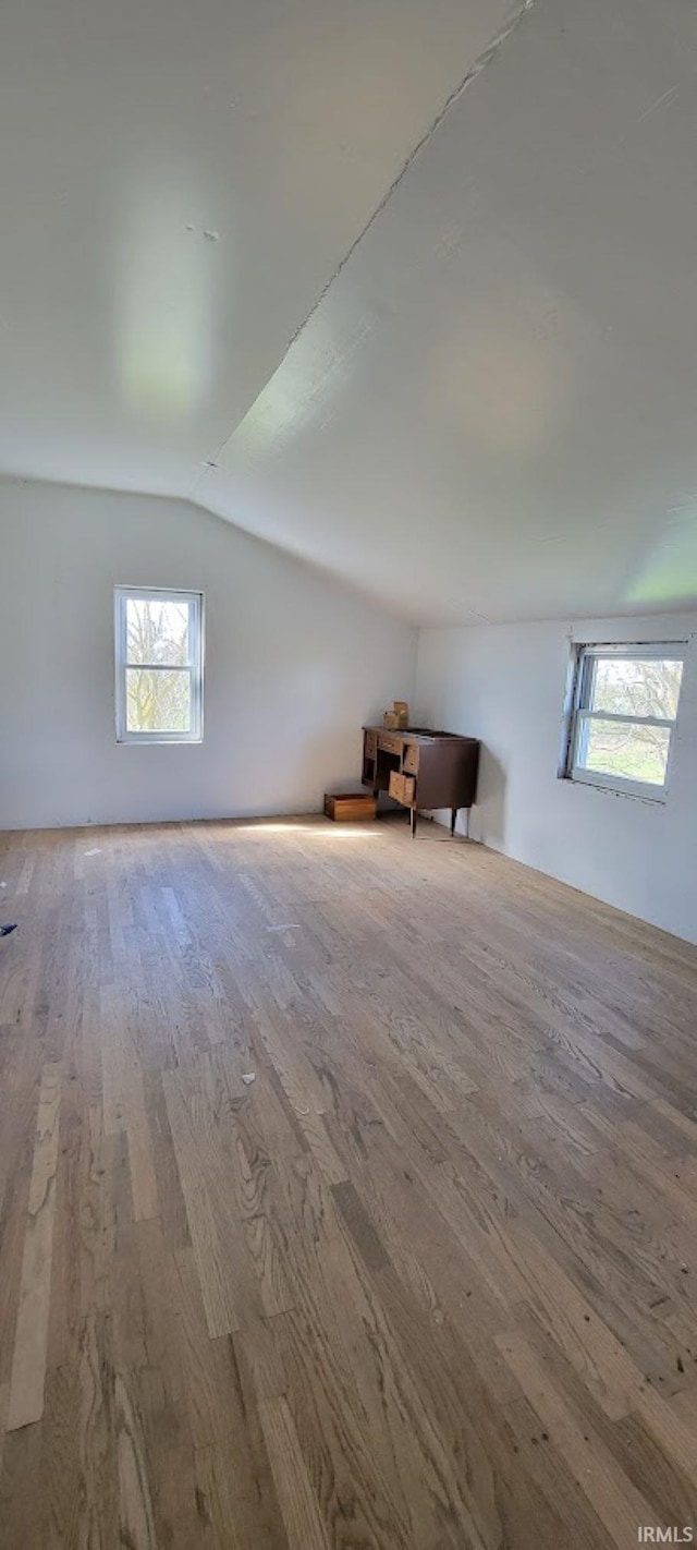 bonus room with lofted ceiling and wood finished floors
