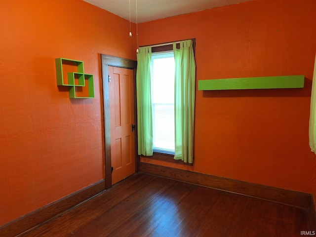 unfurnished room with wood finished floors and baseboards