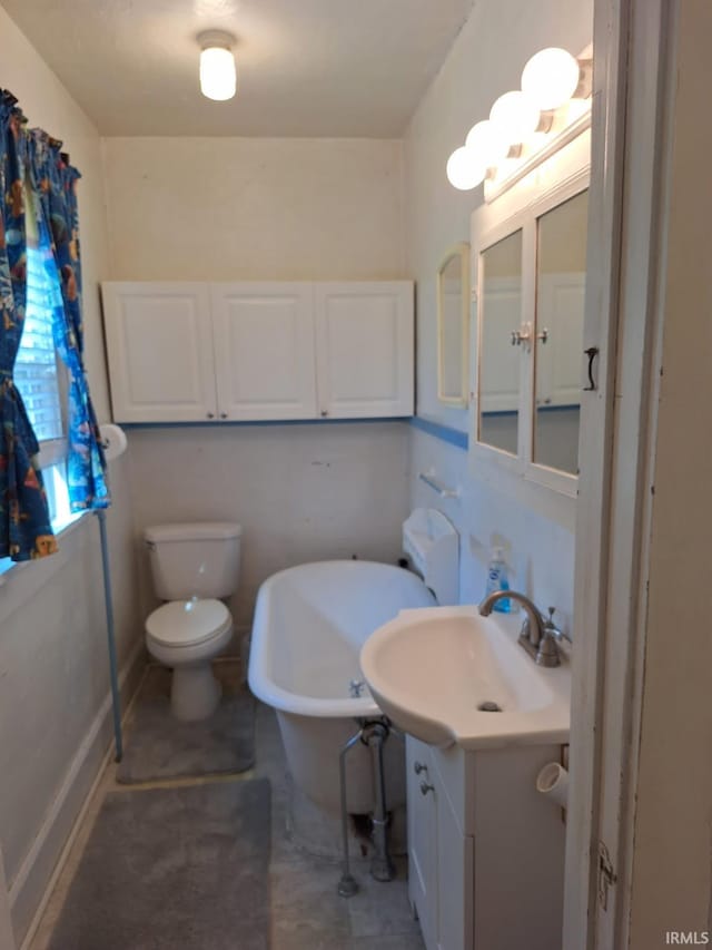 full bathroom with vanity, toilet, and a freestanding tub