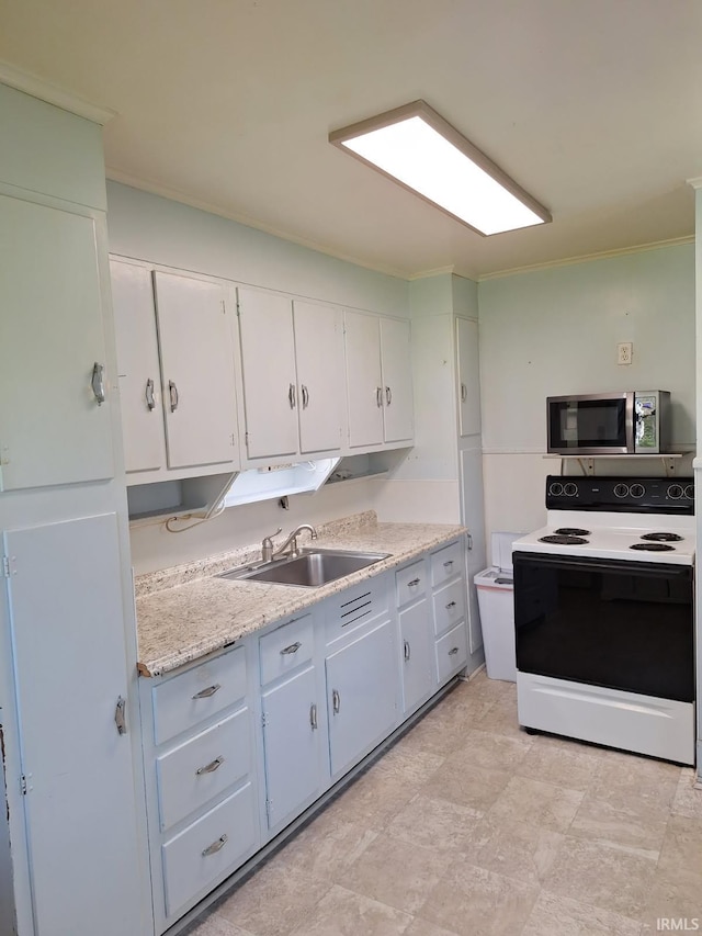 kitchen featuring light countertops, electric stove, a sink, stainless steel microwave, and white cabinetry