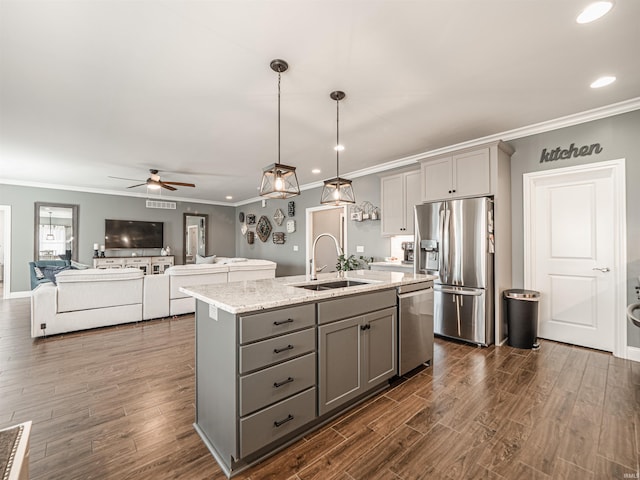 kitchen featuring crown molding, gray cabinets, stainless steel appliances, and a sink