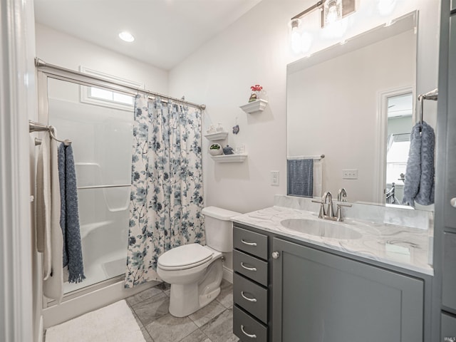 bathroom featuring toilet, vanity, and a stall shower
