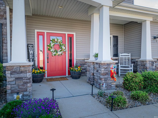 property entrance featuring stone siding and covered porch