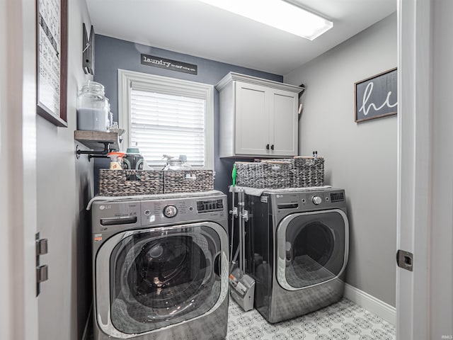 laundry area with baseboards, cabinet space, and washer and clothes dryer