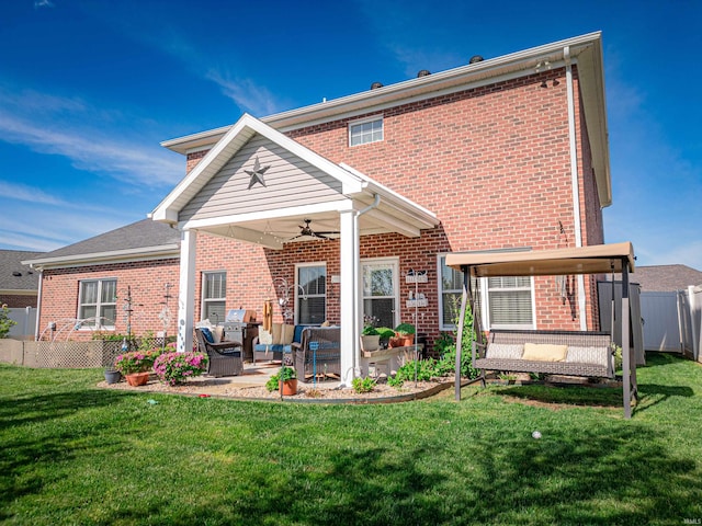 back of house featuring a lawn, a ceiling fan, fence, a patio, and brick siding