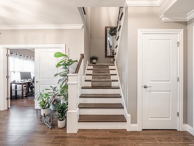 staircase with baseboards, wood finished floors, and ornamental molding