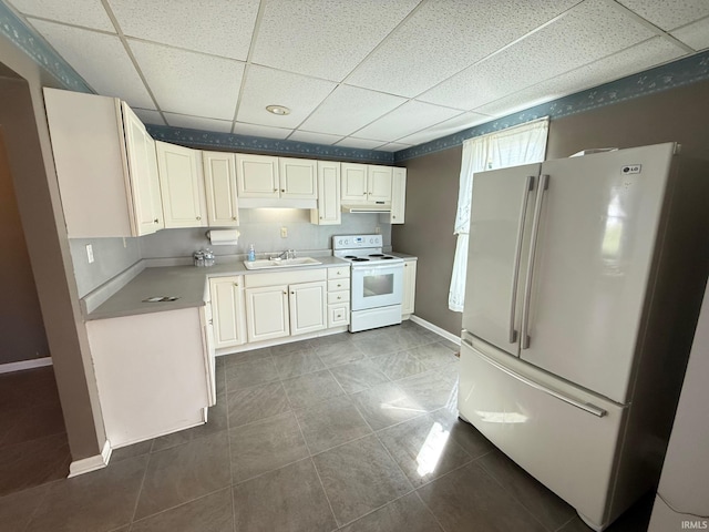 508 E Michigan St, Lagrange, IN 46761 - kitchen with a drop ceiling, under cabinet range hood, light countertops, a sink, and white appliances