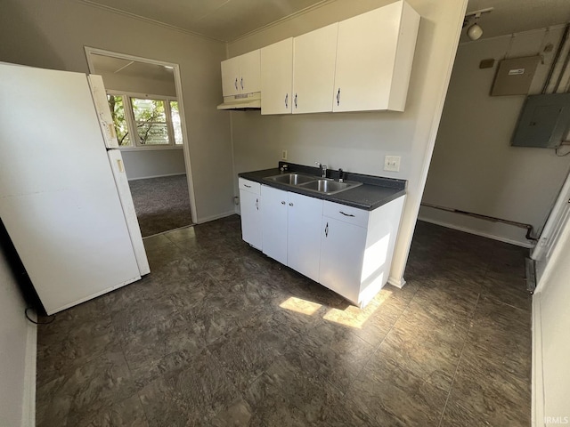 4323 Spatz Ave, Fort Wayne, IN 46806 - kitchen featuring dark countertops, a sink, white cabinets, under cabinet range hood, and freestanding refrigerator