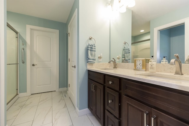 bathroom with marble finish floor, baseboards, a sink, and a shower stall
