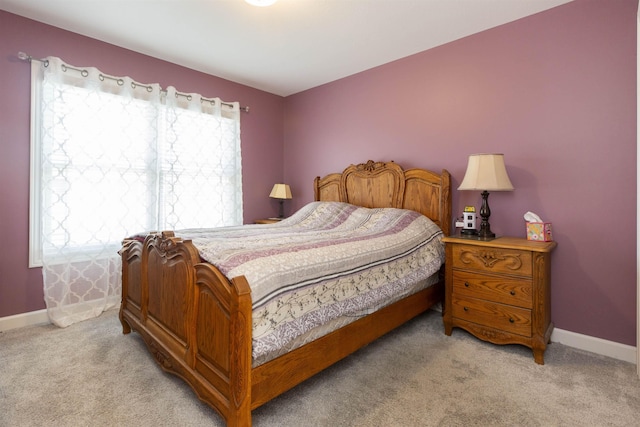 bedroom featuring baseboards and light carpet