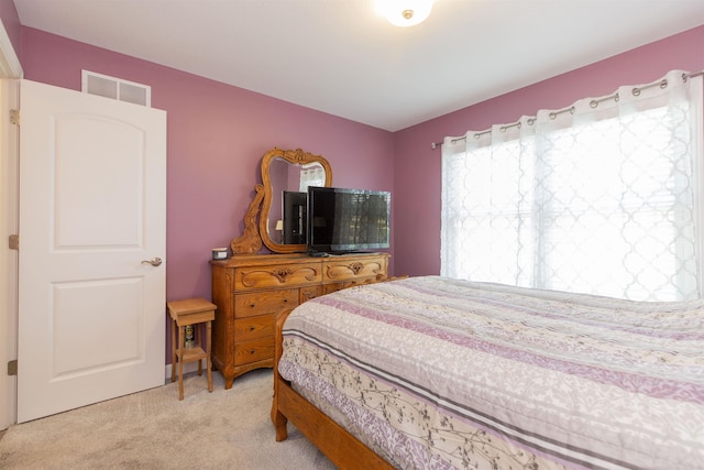 bedroom with visible vents and light carpet
