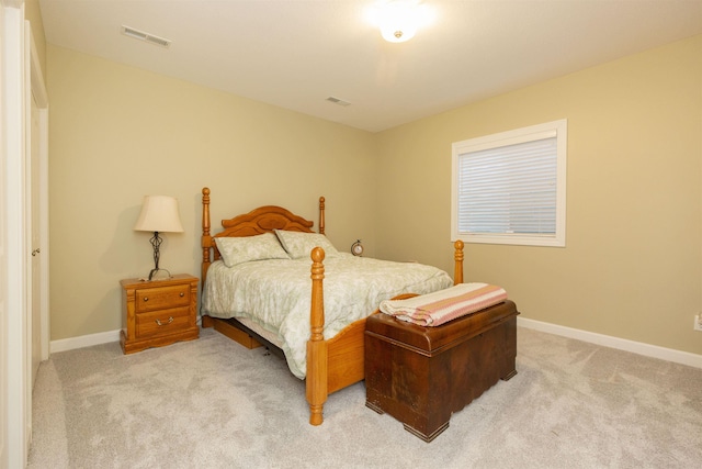 bedroom with visible vents, light carpet, and baseboards