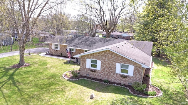 4405 Parkwood Dr, Kokomo, IN 46901 - view of side of property featuring brick siding, a yard, a shingled roof, and crawl space