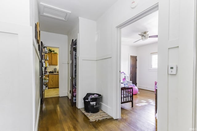 corridor featuring attic access, visible vents, and dark wood finished floors