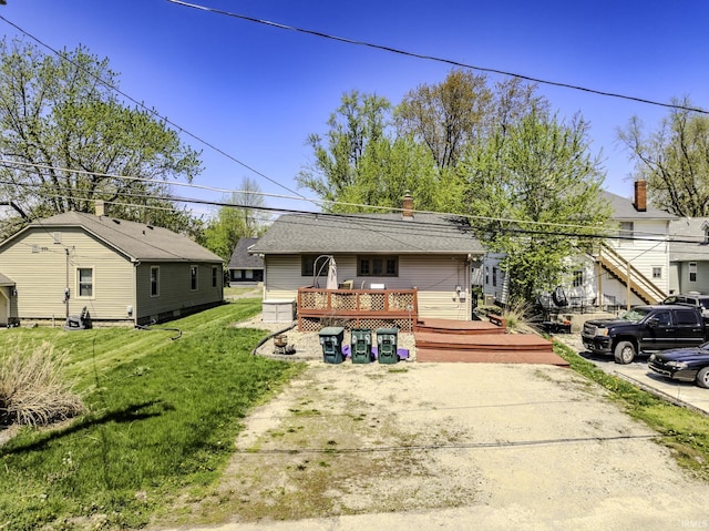 back of house with a lawn, a chimney, and a deck