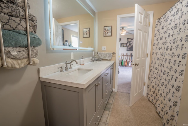 full bathroom featuring a shower with shower curtain, double vanity, ceiling fan, and a sink