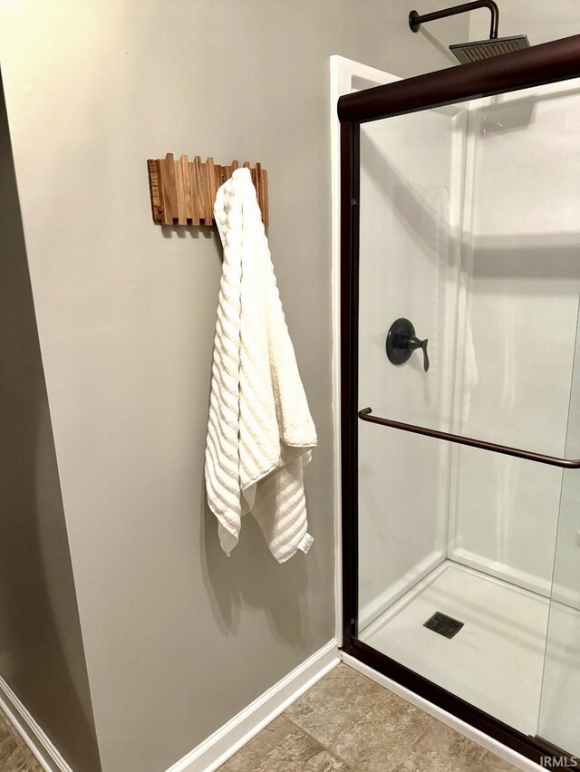 bathroom with baseboards and a shower stall