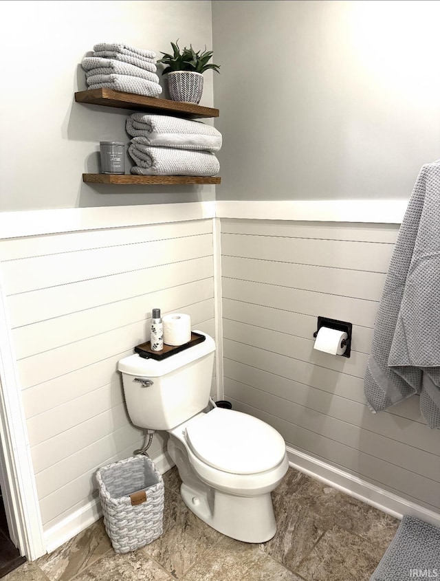 half bath with toilet and baseboards