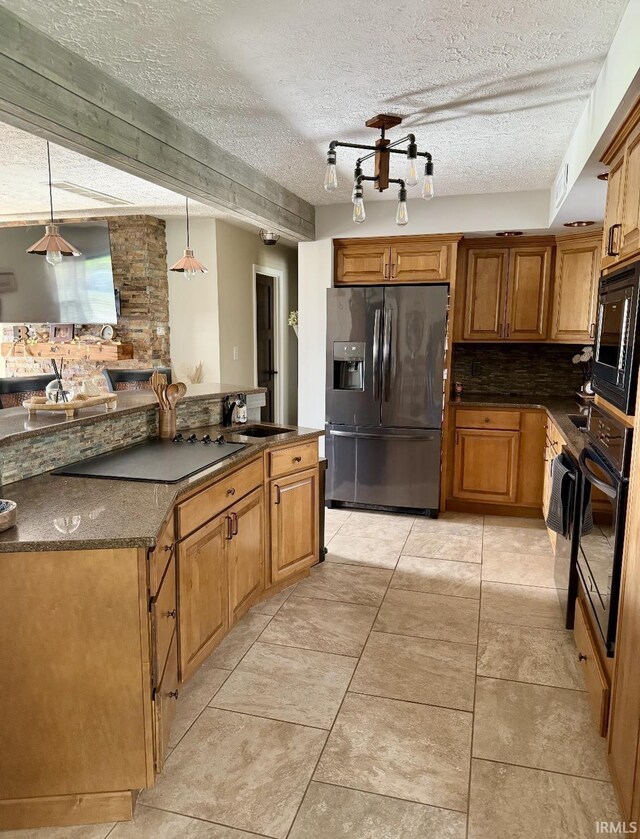 kitchen with black appliances, a sink, brown cabinetry, and tasteful backsplash