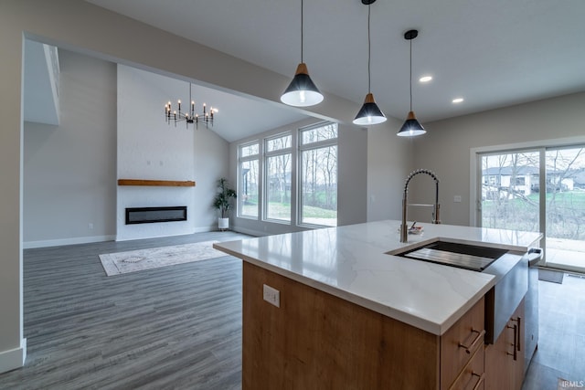 619 Sandringham Pass, Fort Wayne, IN 46845 - kitchen with a large fireplace, recessed lighting, wood finished floors, a kitchen island with sink, and hanging light fixtures