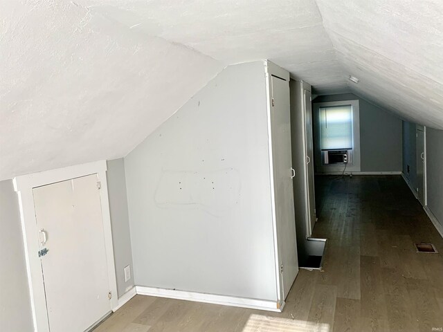 bonus room with baseboards, visible vents, wood finished floors, and lofted ceiling