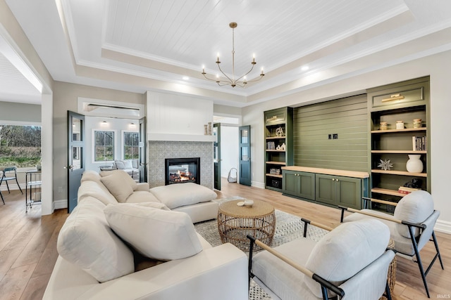 1152 Cascata Trl, Huntertown, IN 46748 - living area with a chandelier, a multi sided fireplace, a raised ceiling, and light wood finished floors