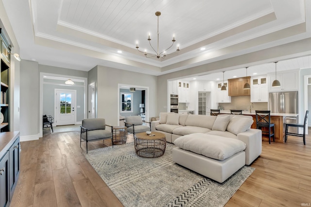 1152 Cascata Trl, Huntertown, IN 46748 - living area with an inviting chandelier, light wood-style flooring, and a tray ceiling