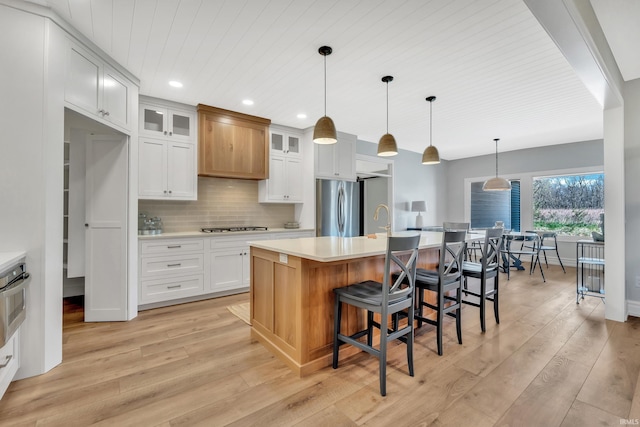 1152 Cascata Trl, Huntertown, IN 46748 - kitchen featuring tasteful backsplash, light wood-style floors, stainless steel appliances, and light countertops
