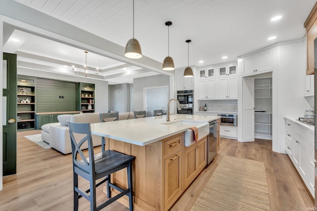 1152 Cascata Trl, Huntertown, IN 46748 - kitchen featuring a breakfast bar area, tasteful backsplash, light wood-style flooring, appliances with stainless steel finishes, and open floor plan