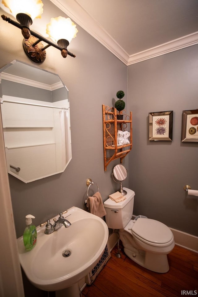 826 College Ave, Culver, IN 46511 - bathroom with wood finished floors, toilet, ornamental molding, a sink, and baseboards