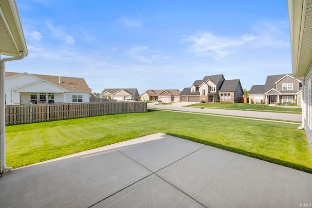view of yard with fence, a residential view, and a patio area