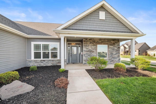 view of front of property featuring a porch, a shingled roof, and stone siding