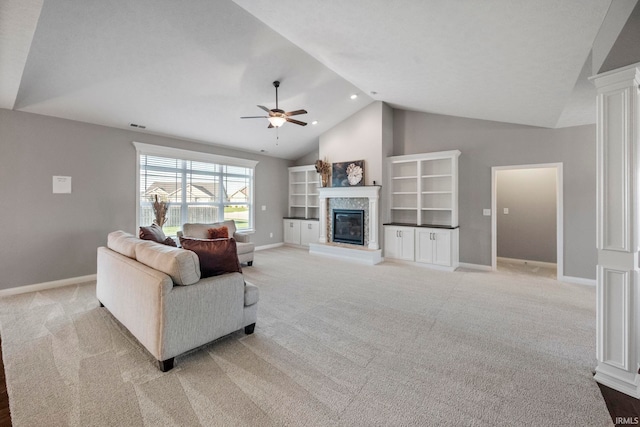 living area with a glass covered fireplace, light colored carpet, a ceiling fan, and baseboards