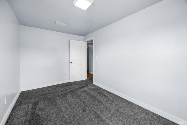 601 W Sherman St, Windfall, IN 46076 - spare room with baseboards, visible vents, and dark carpet