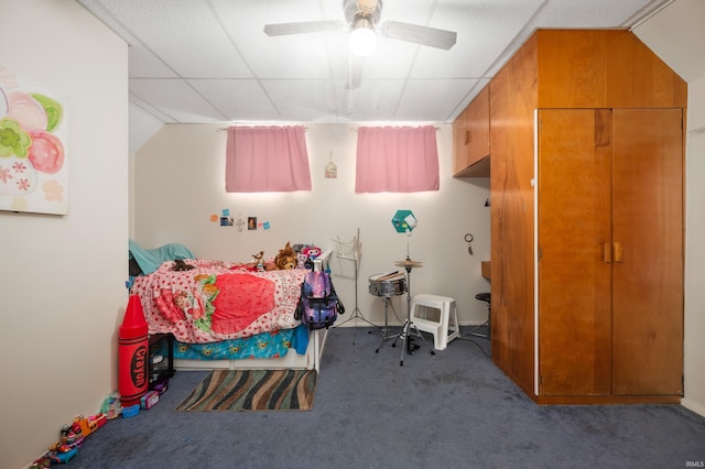 bedroom with ceiling fan, carpet floors, and a drop ceiling