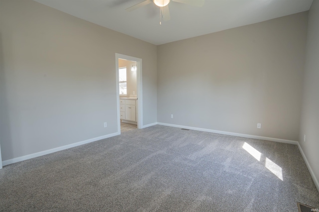 spare room featuring visible vents, a ceiling fan, baseboards, and light carpet
