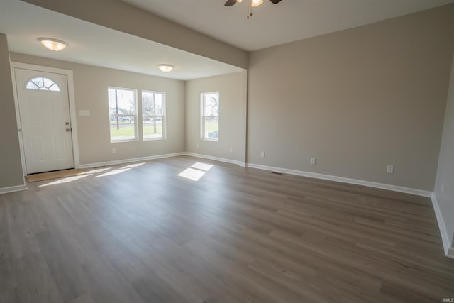 foyer featuring baseboards, visible vents, ceiling fan, and dark wood finished floors